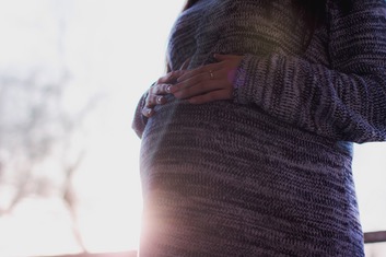 Femme enceinte, les mains posées sur son ventre