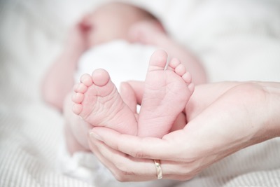 Pieds d'un nourrisson posés dans la main d'un parent