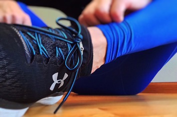 Sportif en train de s'étirer, chaussure de course au premier plan